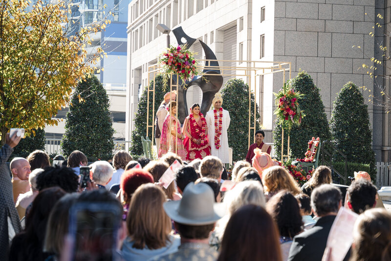 Traditional Indian wedding ceremony with bride and groom standing with family at the Grand Bohemian Hotel Charlotte, beautifully captured by an experienced Indian wedding photographer in Charlotte.
