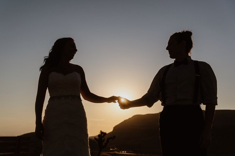 Couple tenderly holding hands during their sunrise adventure elopement portraits