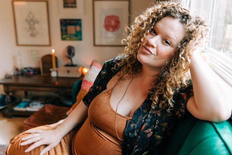Rachael Maddox, business oracle witch, sitting on a green velvet couch showcasing the clear, confident feeling you can have when you write sales copy with her Sales Page Siren magick.