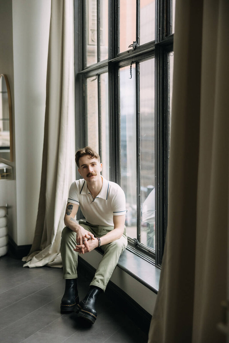 Mark sitting on window sill, Finger Lakes videographer