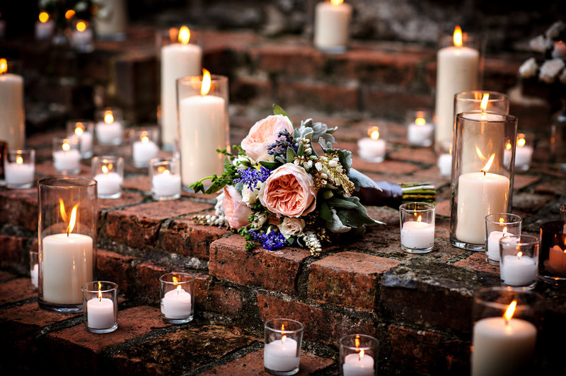 A bouquet of flowers surrounded by candles at a wedding in MD at the Patapsco Female Institute.