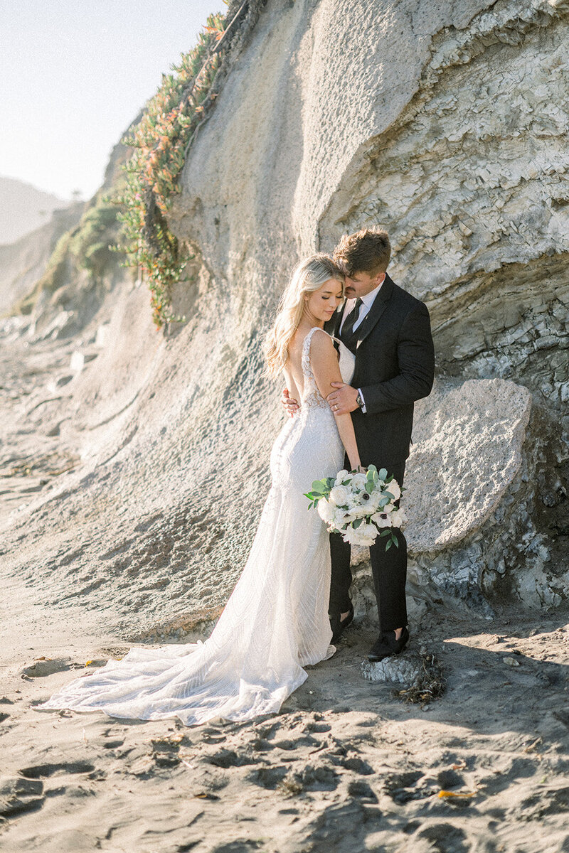 A breathtaking scene from a luxurious beachfront wedding in Pismo, CA, captured by Tiffany Longeway, showcasing the serene beauty of a sunset ceremony by the ocean.