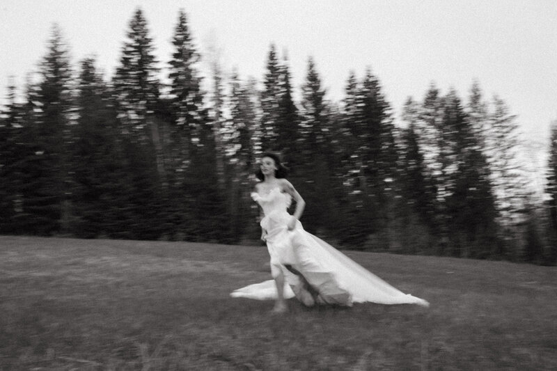bride running through field in wedding dress