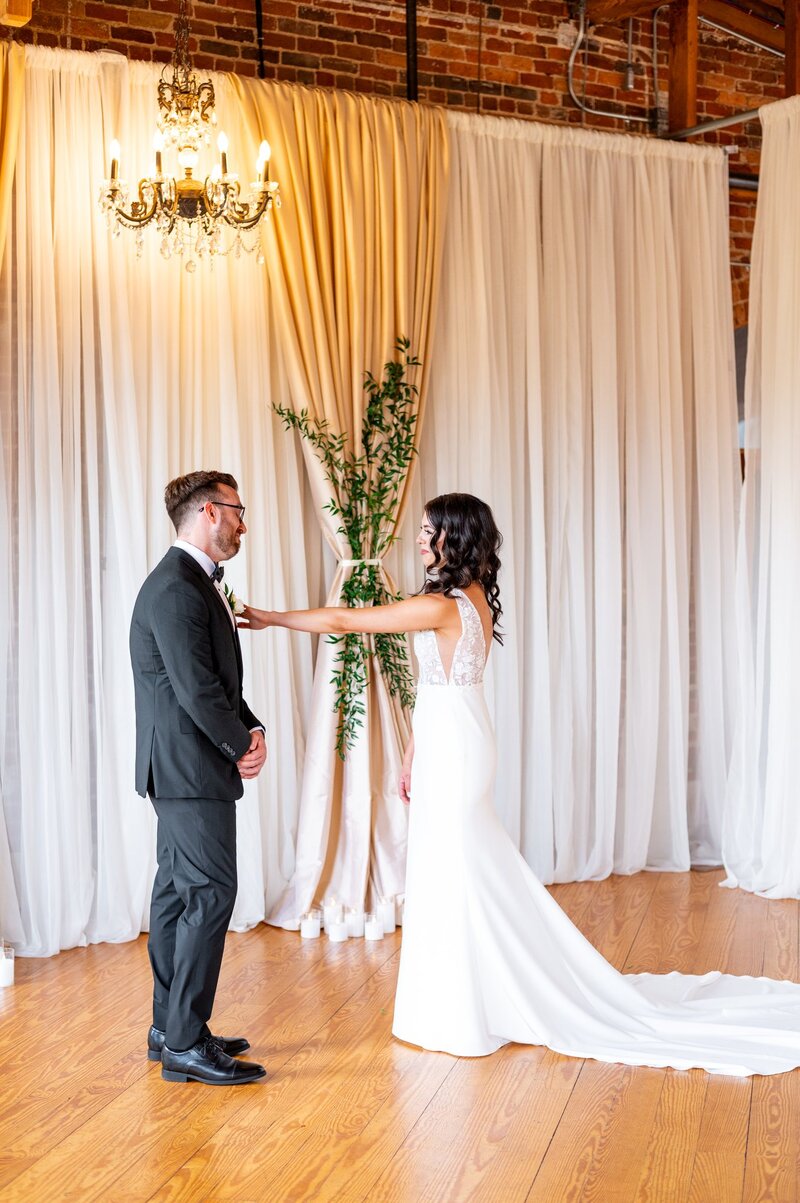 A wedding day photo of a bride standing against a beautiful cream colored stone and huge columns.