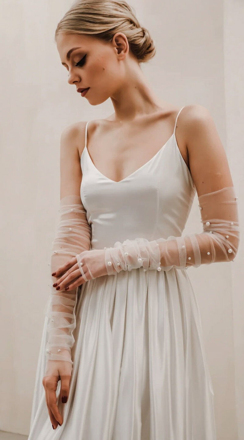 Woman wearing a off shoulder fitted dress and a lace sleeve