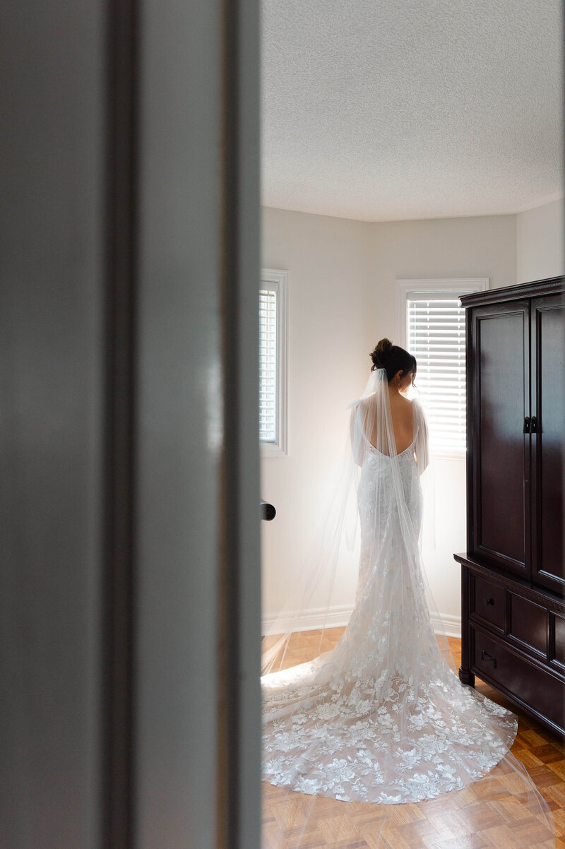 a full length photo of a bride taken from behind as she waits for her reveal with her father.  Taken by Ottawa wedding photographer JEMMAN Photography