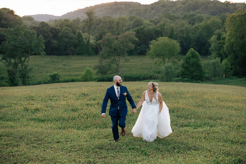 bride and groom hold hands and run through field on wedding day in lancaster pa
