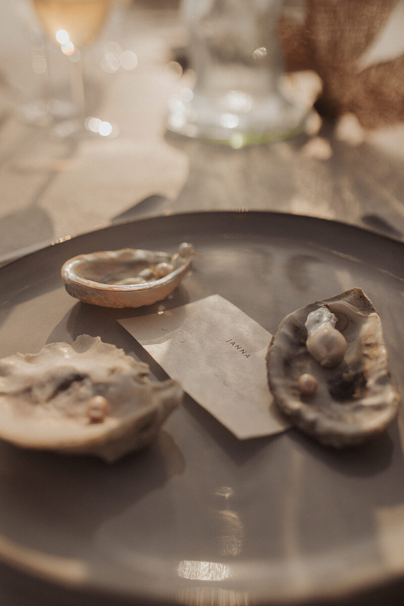 Elegant place settings with oysters and personalized name cards at a wedding reception.