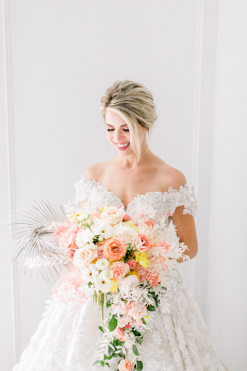 Bride with sunset colored bouquet at chateau cocomar
