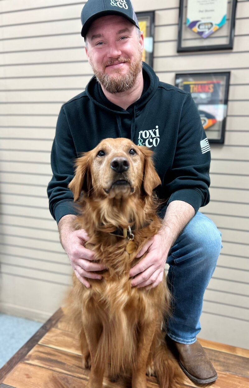 Telly from Roxi & Co smiling with Cash, his golden retriever, highlighting the people and pets behind Roxi & Co careers.