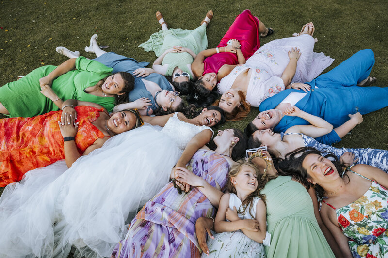 A bride and her best friends lying on the grass in a circle