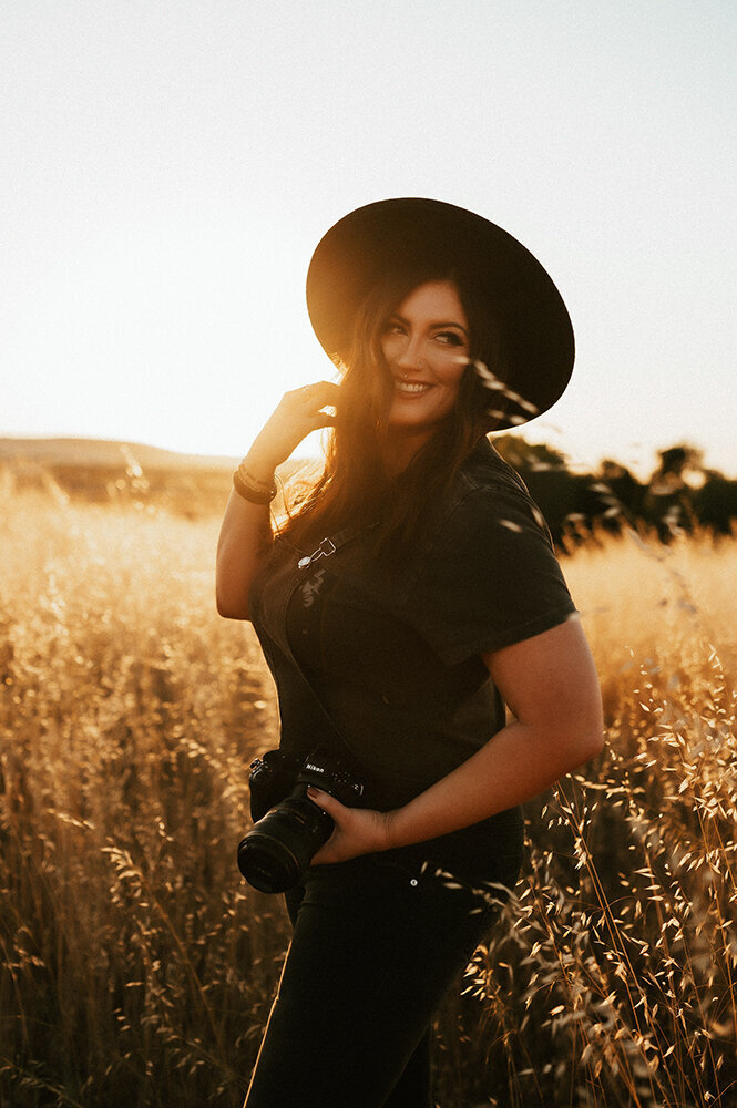 Family Photographer Aspen Dawn Smiling in a black hat.