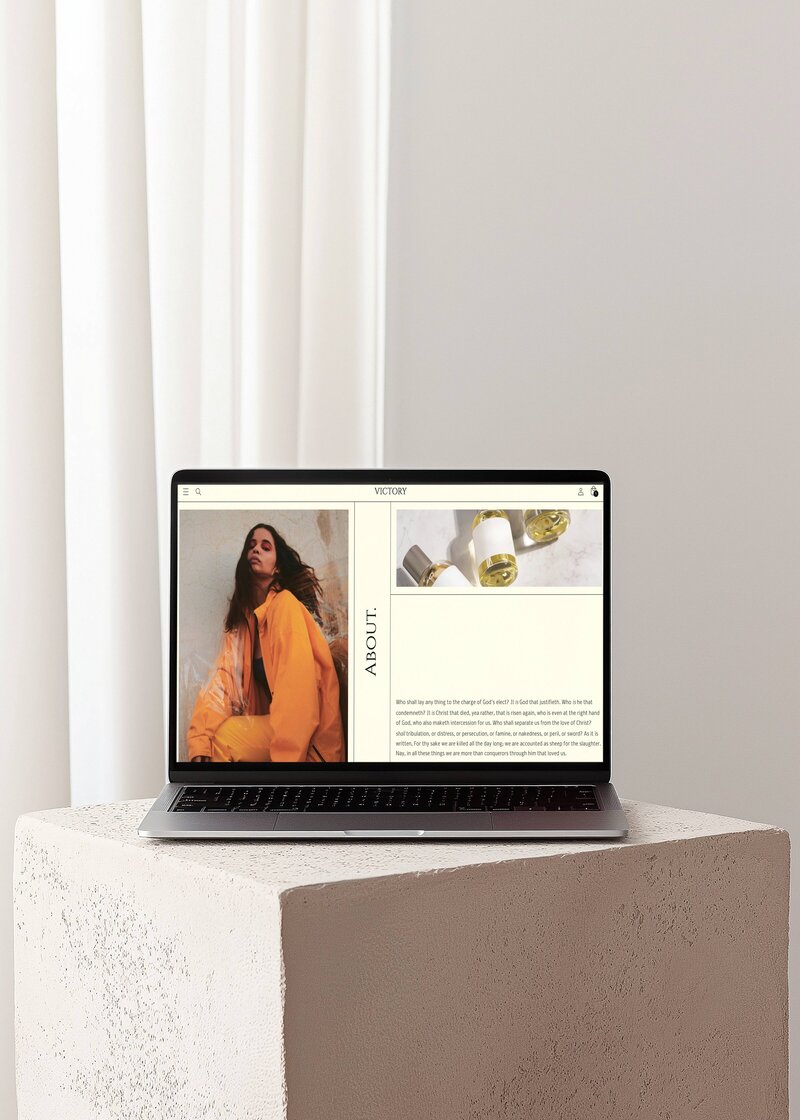Victory website About page showcased on an open Macbook Pro laptop sitting on top a stone pillar