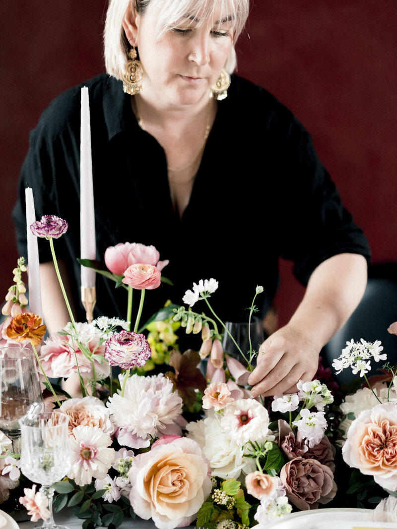 Carmel adjusts an arrangement of lush flowers at a wedding in Montreal. 