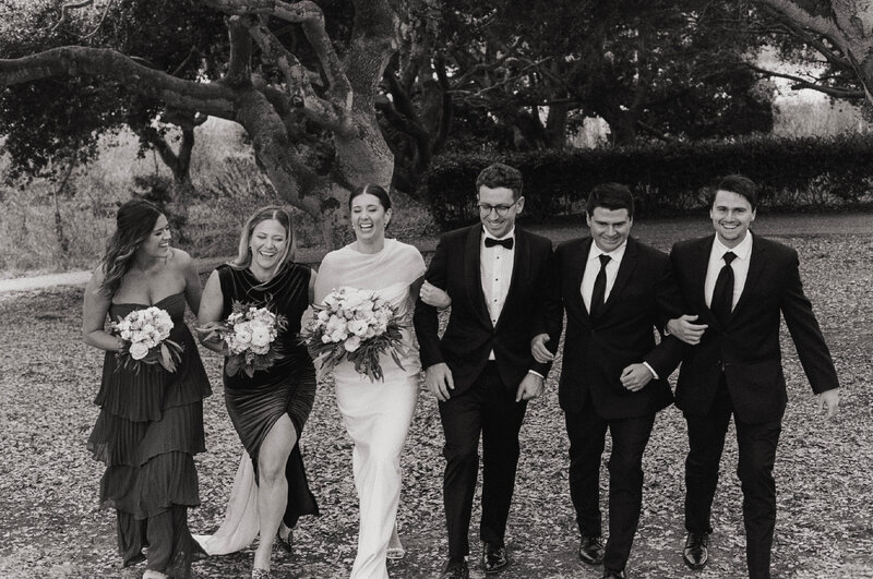 black and white photo of wedding party smiling
