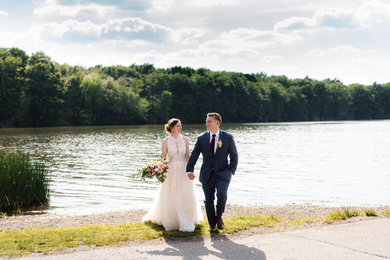 bride and groom walking and holding hands at Moraine State Park