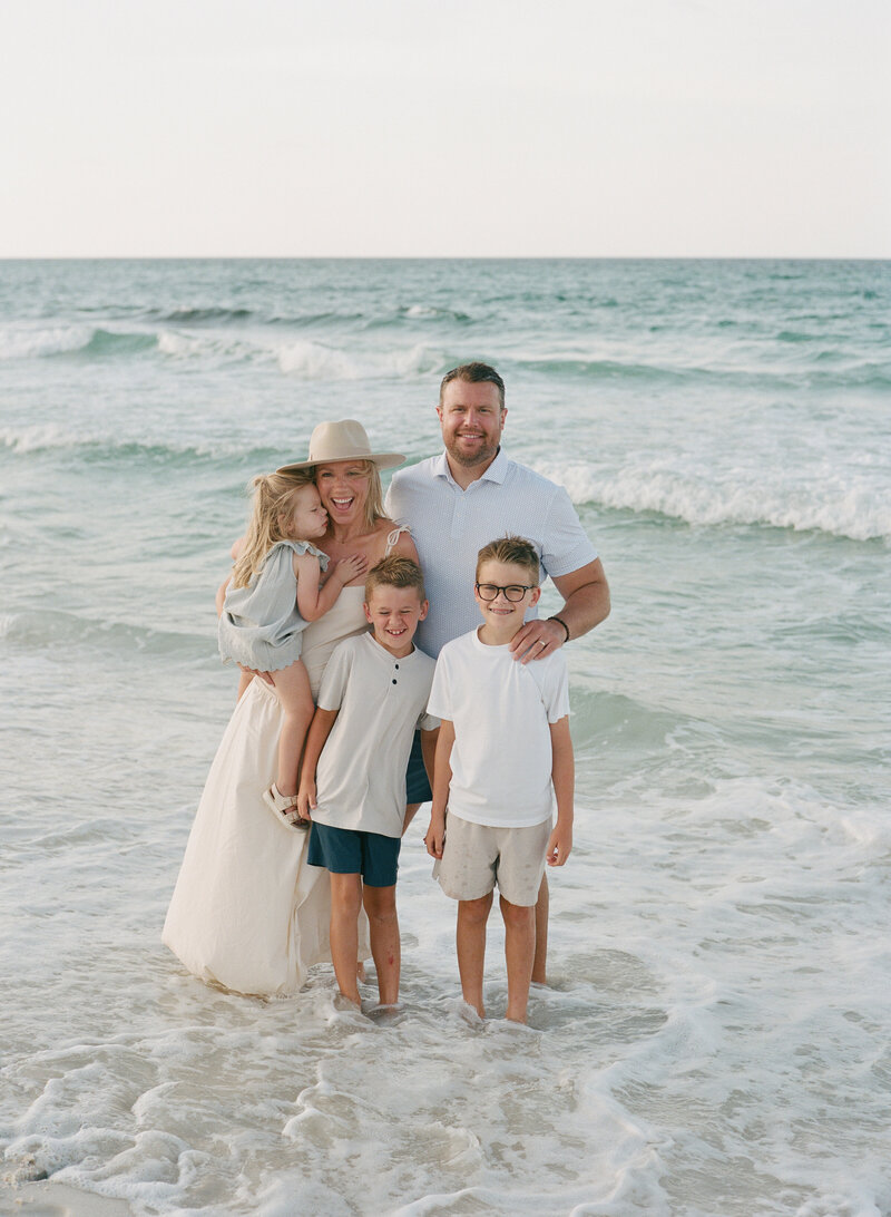 film photo of a family at rosemary beach laughing with the waves