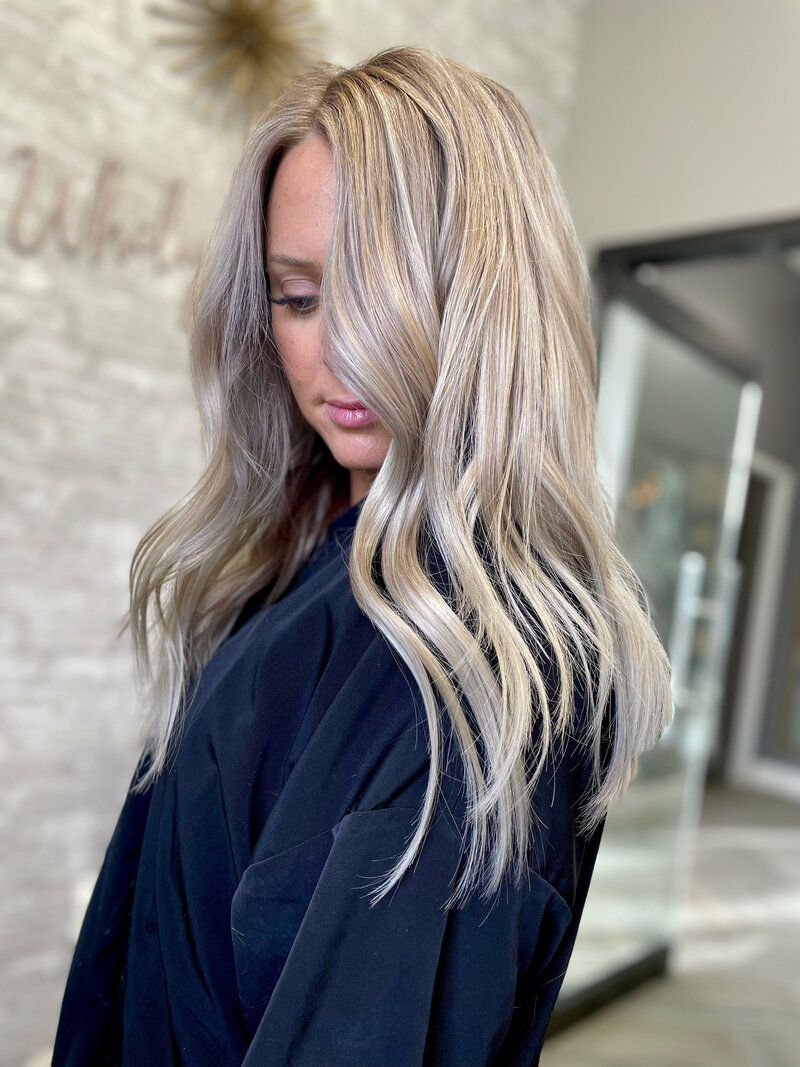 woman with long platinum blonde hair looking down