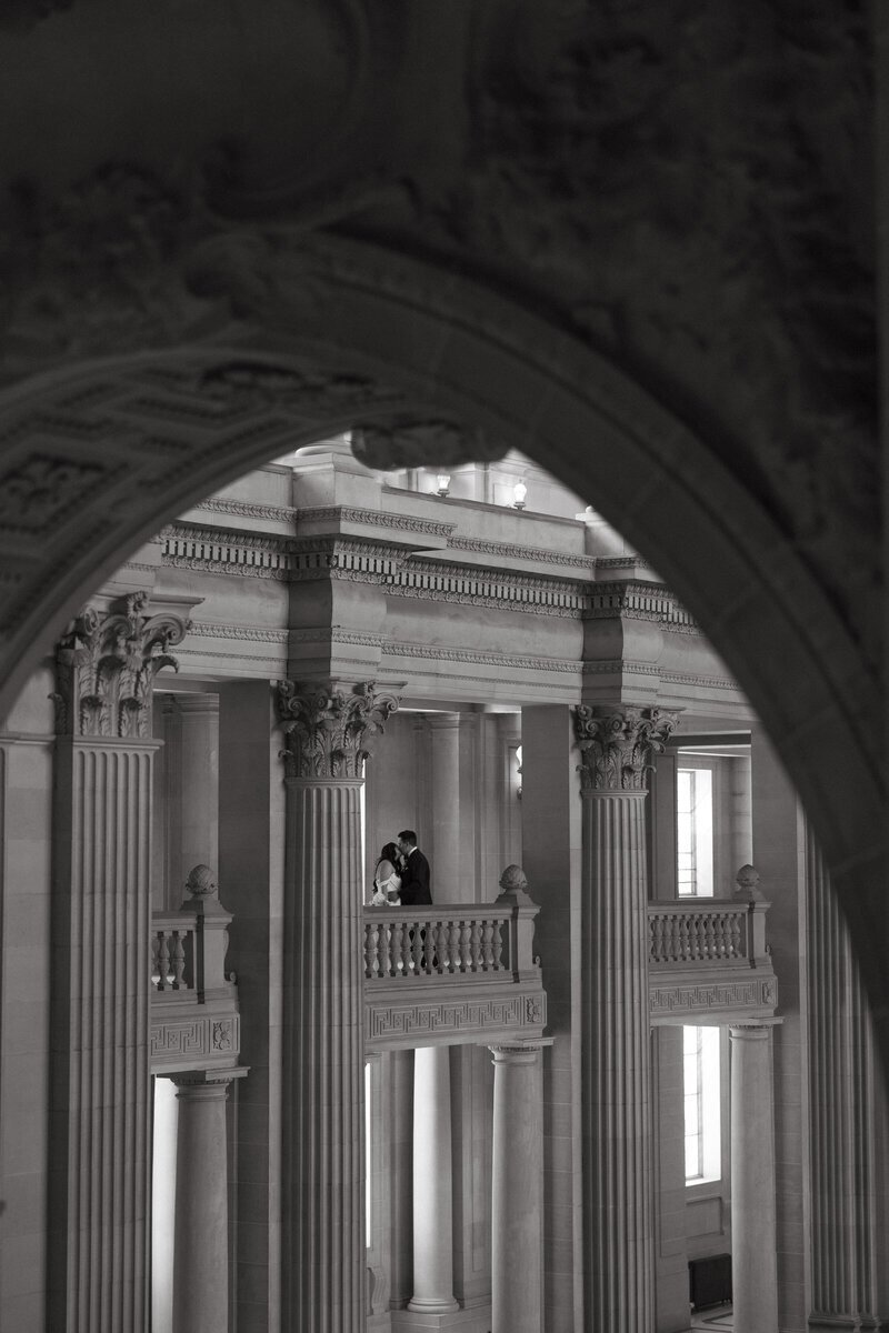 Bride and groom kissing in San Francisco City Hall by destination wedding photographer Erica Rochelle Photography