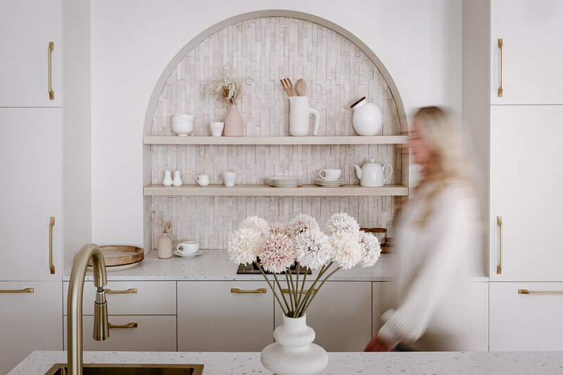Blurred image of a women walking through her natural texture kitchen