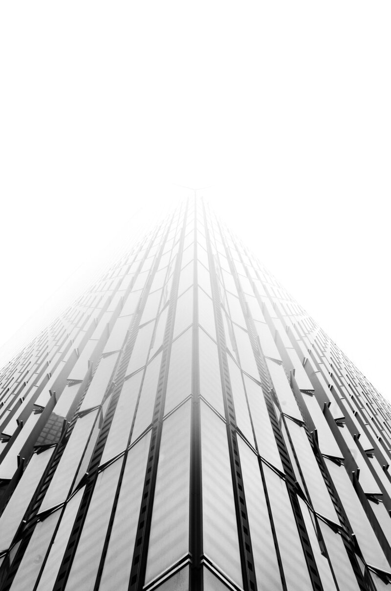 Looking up at a tall building, representing the goals and aspirations clients reach through private coaching.