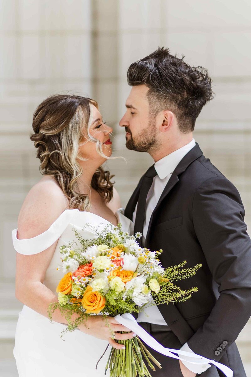 Portrait of bride and groom smiling at each other at the Wrigley Building