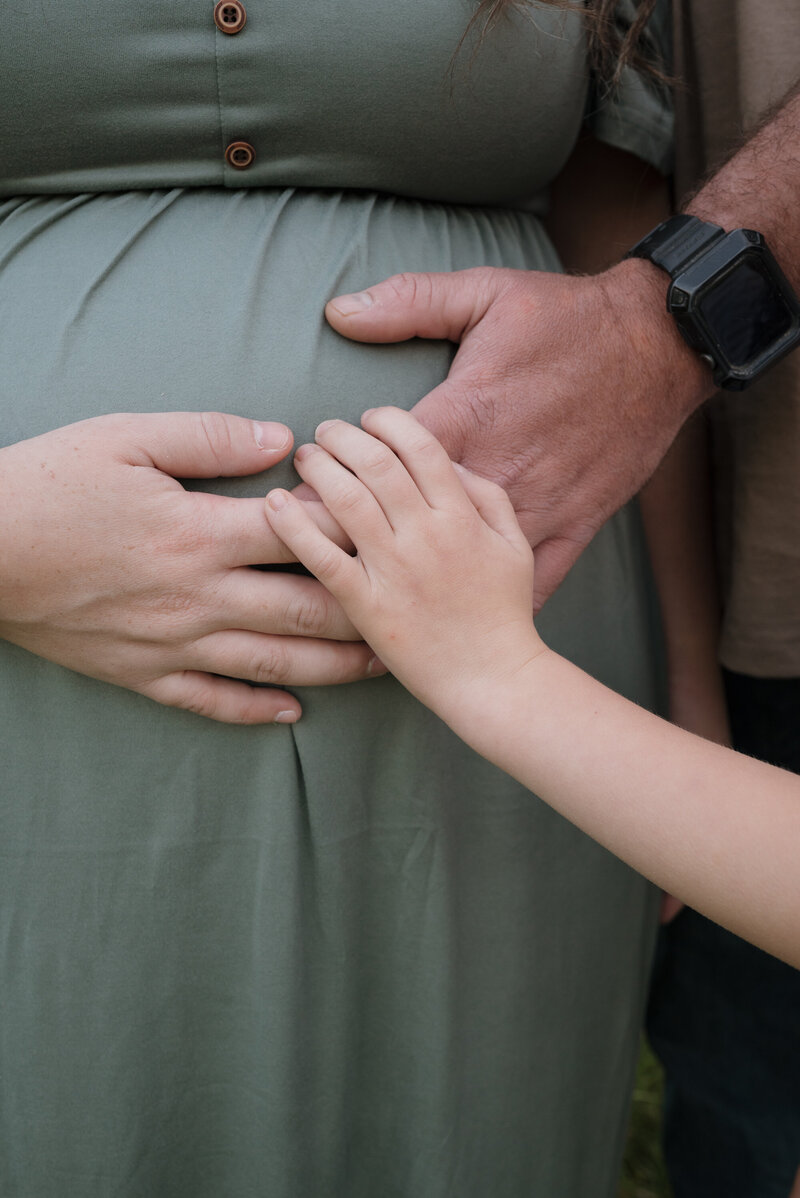 Expecting Mom with family hands 