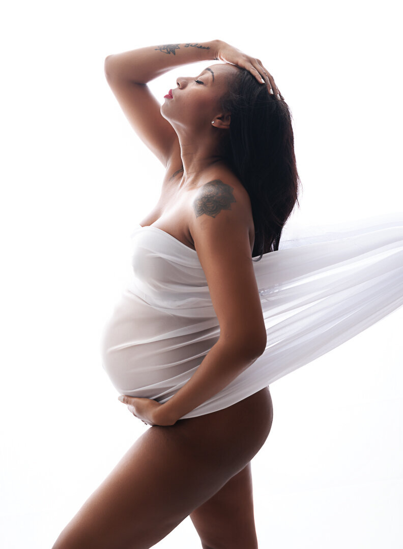 maternity mom back lit wearing white fabric