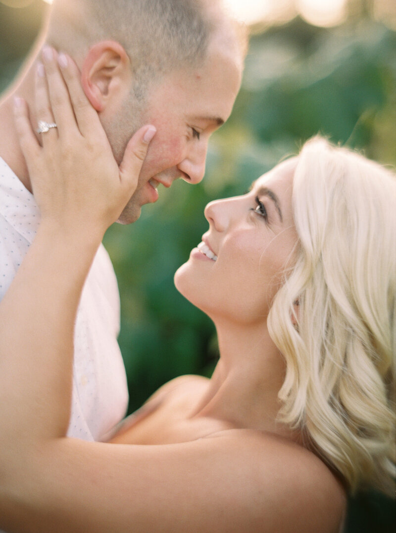 seattle wedding photographers loving romantic couple touching face delicately in soft golden light in vineyard