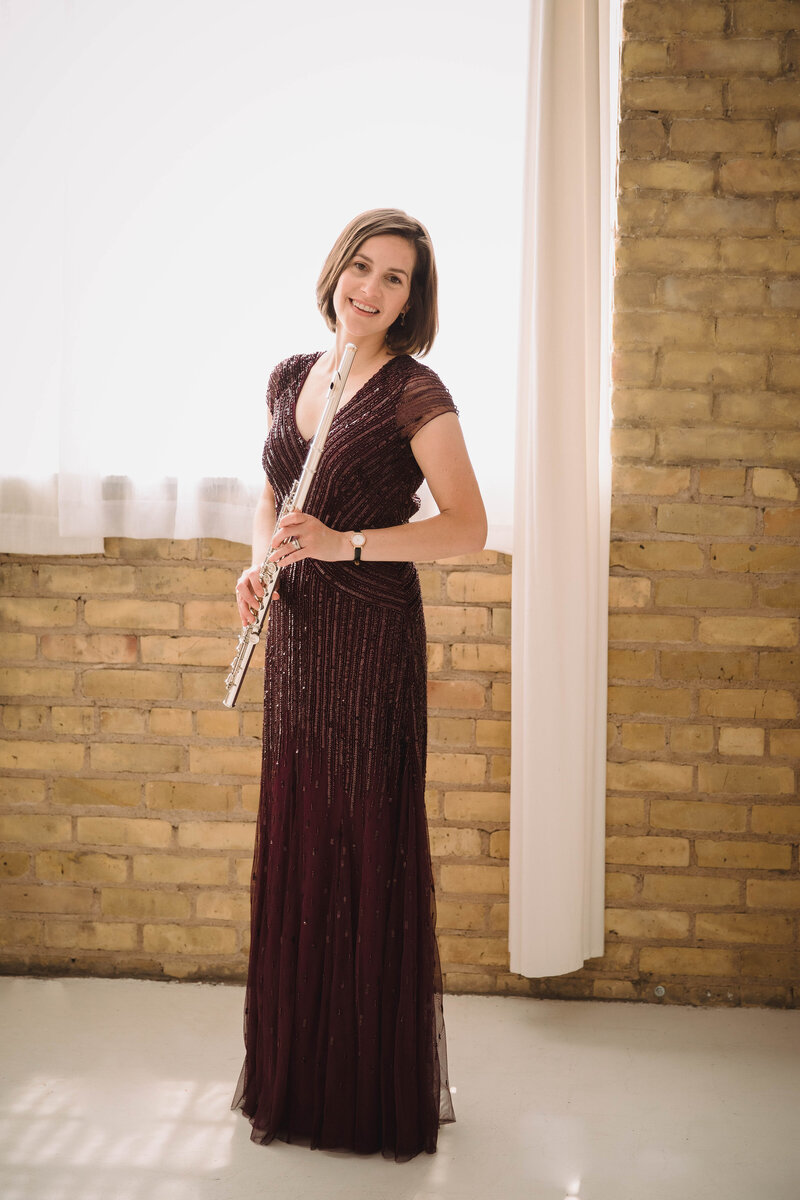 Sarah Weisbrod, Flutist & Teaching Artist, Stainding with Flute in a Purple Dress