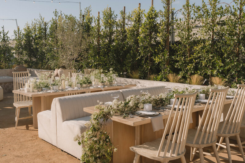 Our Mellow Dining Chair in peach at a table with a linen and a stunning tablescape with our rentals from Catalog and our Scalloped Rattan Lights hanging above. 
