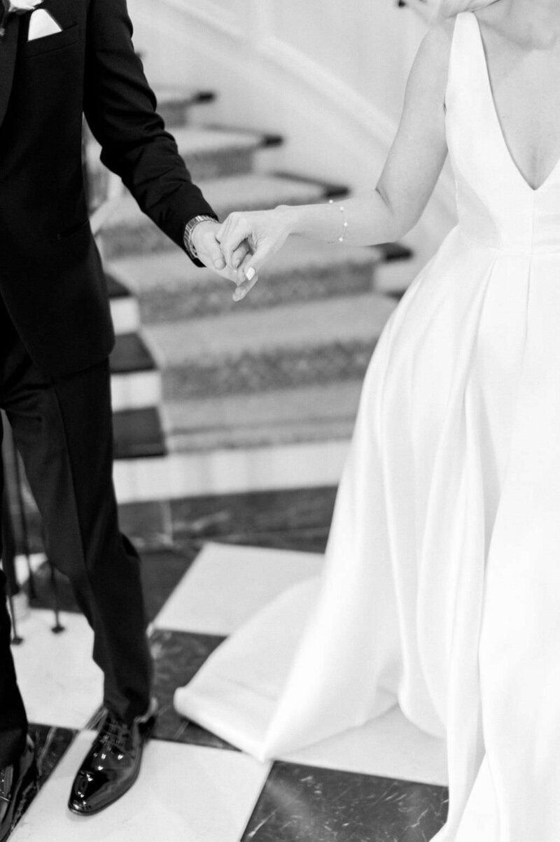 Close up of bride and groom holding hands