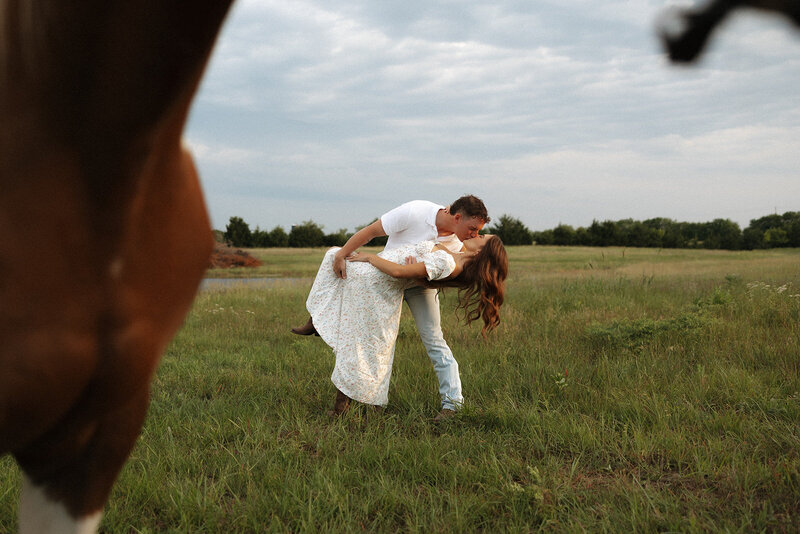A couple about to kiss during their sunset portraits at Great Plains Nature Center in Wichita, KS, capturing a tender and romantic moment as the golden light of the setting sun surrounds them.