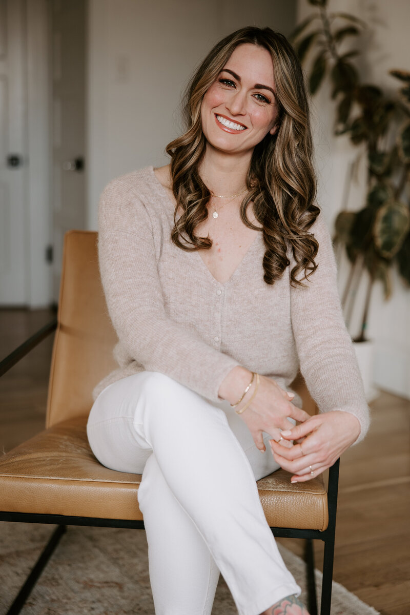 Website copywriter Erika Fitzgerald sitting in a leather chair in her home, where she specializes in SEO conversion copy for service providers 