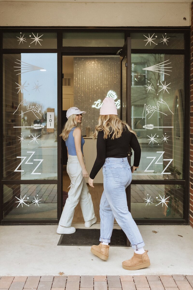 Two Austin women walking into Luna Lash studio
