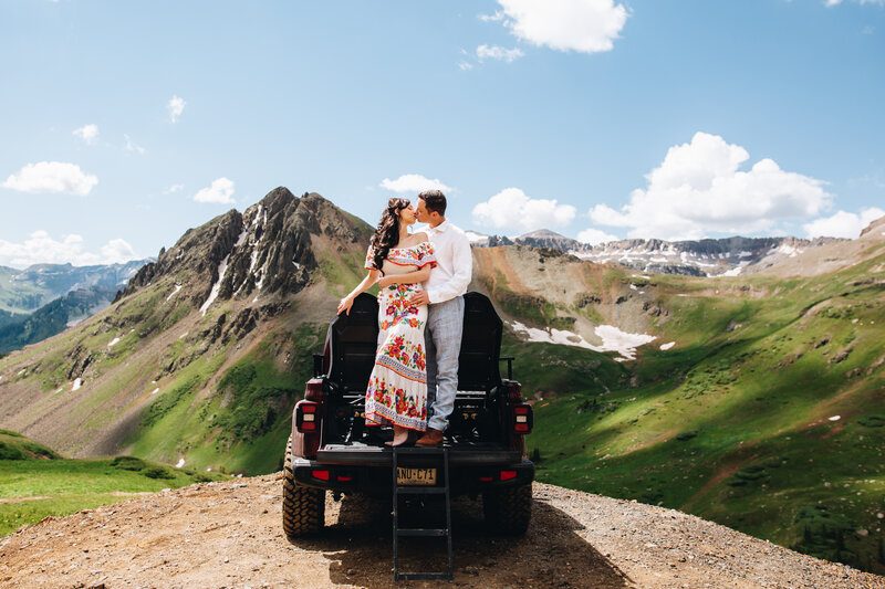 Couple kisses on top of a jeep in Ouray, Colorado.