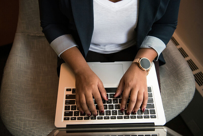 Stock photo, top view of hands typing on a MacBook keyboard. 