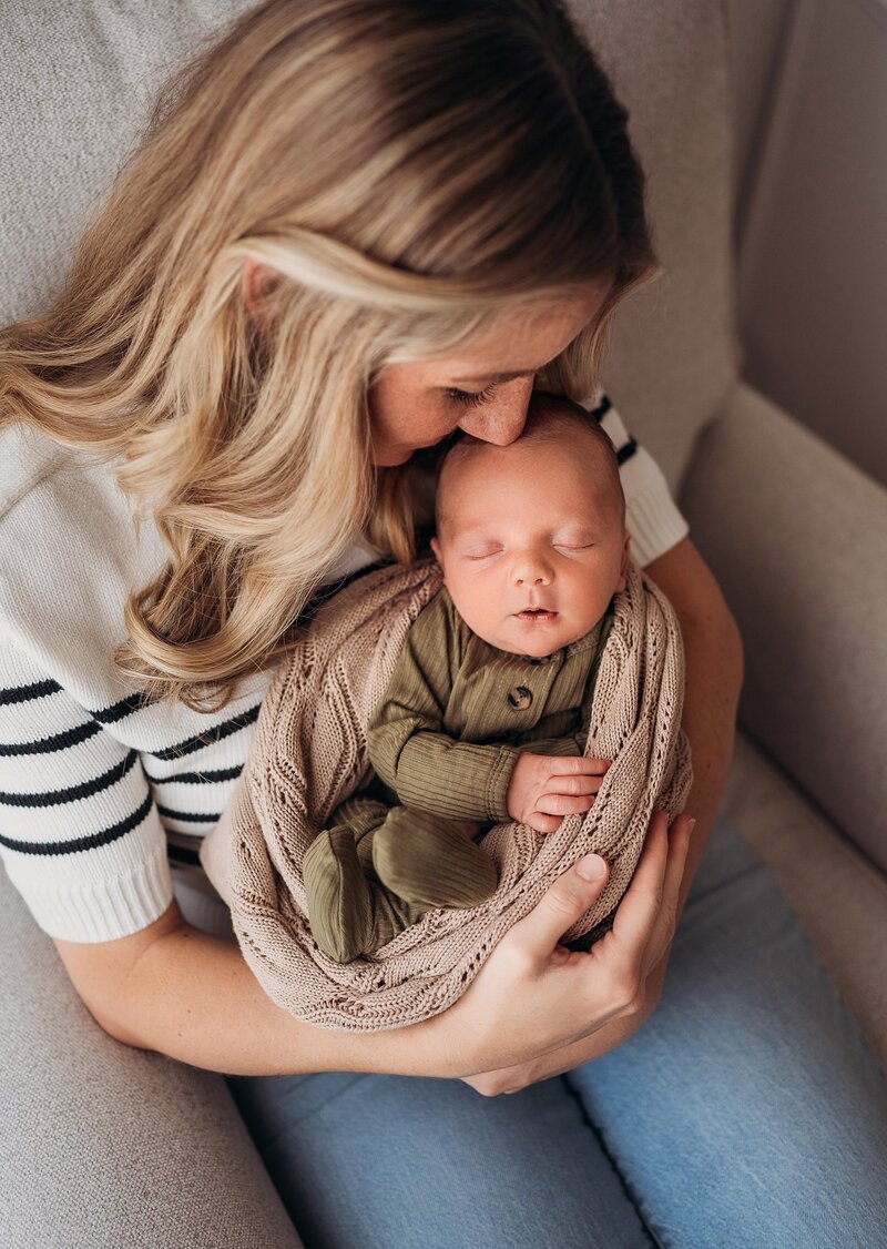 mom kissing newborn baby