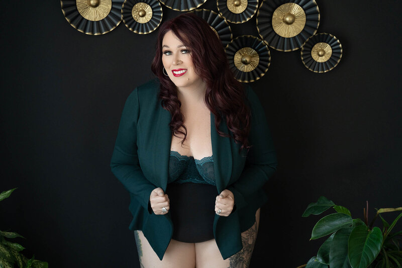 During a boudoir photoshoot in Vancouver a women smiles and poses with red lips