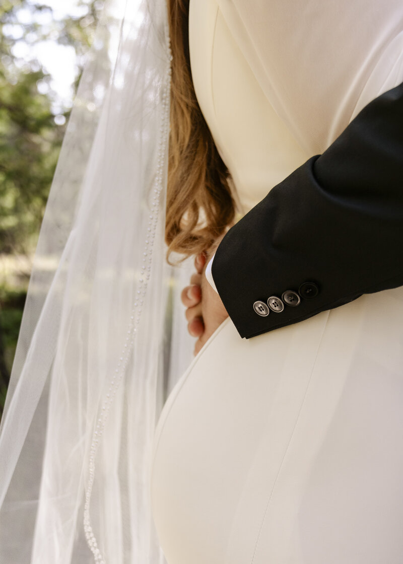 groom's arms around bride's waist