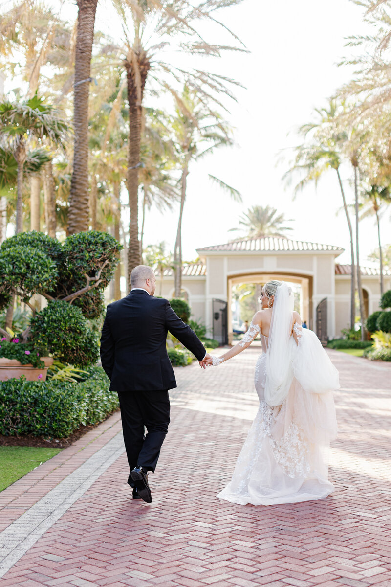 A beautiful wedding couple walking hand-in-hand at The Breakers in Miami, Florida, captured by Claudia Amalia Photography, a wedding and lifestyle photographer based in Miami and Florida Keys South Florida, specializing in destination weddings.