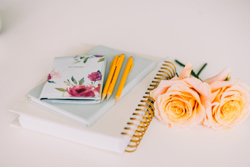 notebooks and flowers sitting on a desk