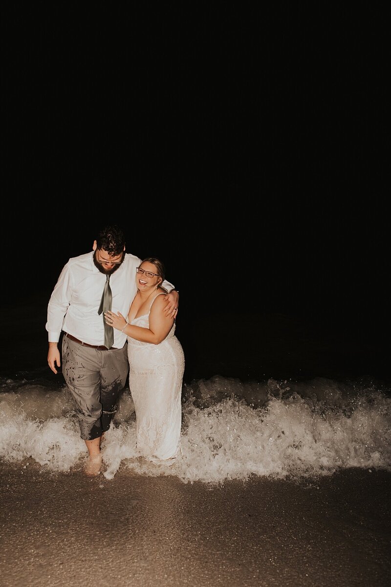 Couple popping champagne at night after their St. Augustine elopement