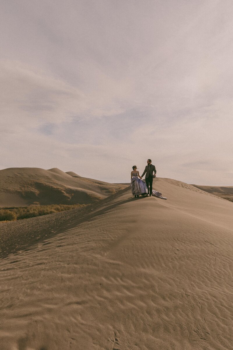 Desert elopement couple holding hands in Idaho