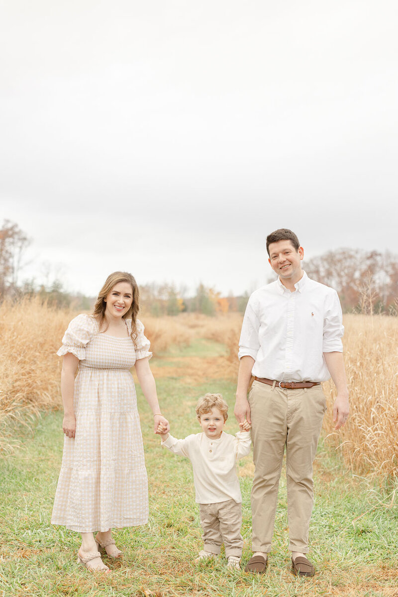 Family of 3 standing & smiling for pictures in Manassas, VA