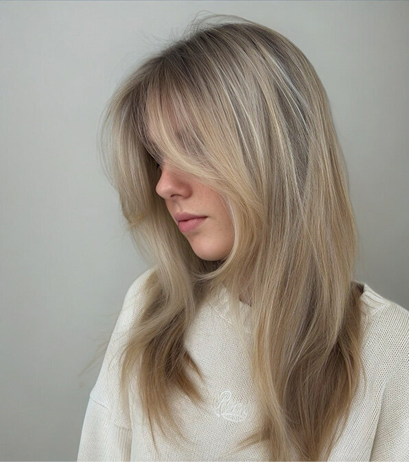 Smooth, layered blonde hairstyle with subtle balayage, perfecting blow-dry styling and colouring techniques during in-salon training.