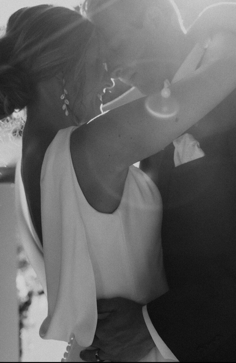Alana and Ryan standing together on their wedding day, in a black and white photo