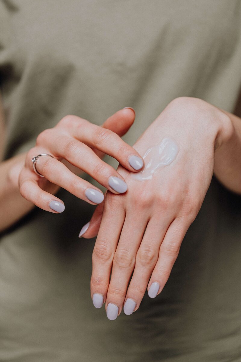 feminine hands rubbing lotion onto hands