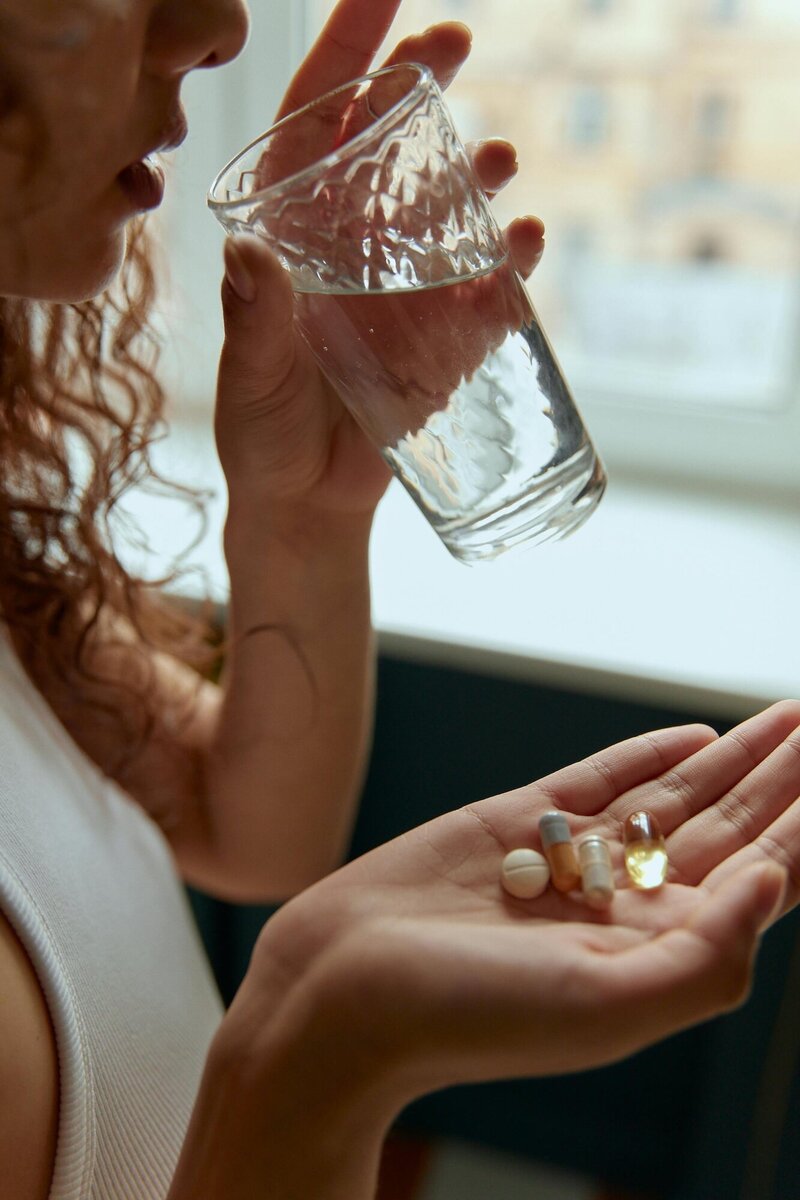 Woman holding vitamins in her hand