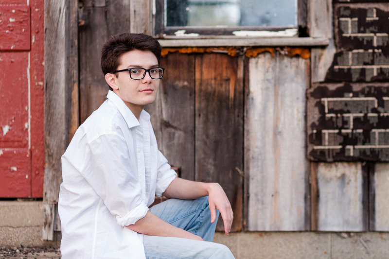 waynedale high school guy sitting in front of an old abandoned building, photographed by Jamie Lynette Photography Canton Ohio Senior Photographer